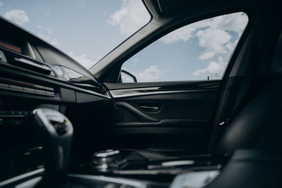 Sleek car interior showcasing gearshift and view through window with clear sky.