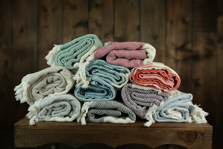 Photo Of Folded Blankets Lying On The Wooden Table