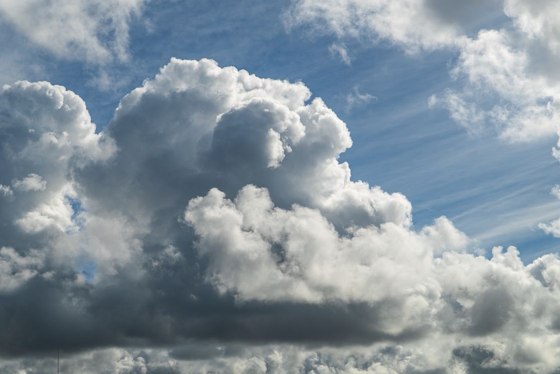 Free A captivating cloudscape featuring white fluffy clouds against a blue sky, showcasing nature's beauty. Stock Photo