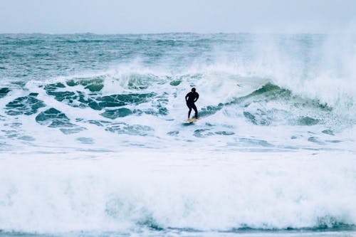 A Man Surfing on Ocean Waves