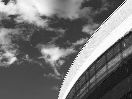 Grayscale Photo of a Concrete Building under the Cloudy Sky