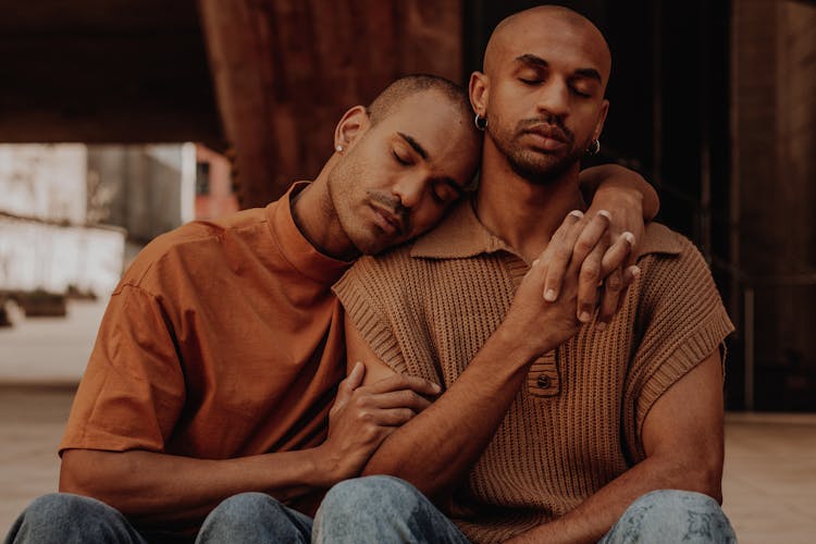 Couple Sitting And Holding Hands And Arms Around Each Other 