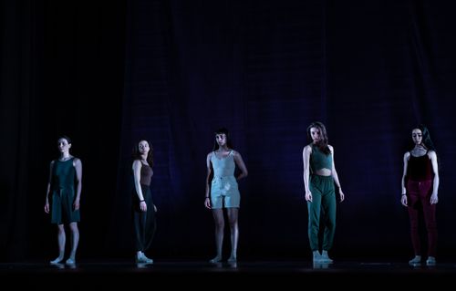 Free Five women dancers pose dramatically on a dimly lit stage, capturing the essence of contemporary dance. Stock Photo