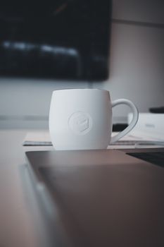 Elegant white mug on an office desk, perfect for coffee or tea enthusiasts seeking a minimalist style.