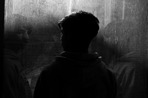 Free Silhouette of a man reflecting on a window, creating a moody and contemplative scene. Stock Photo