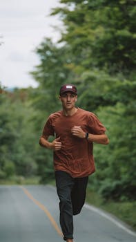 A man jogging on a road amidst lush green outdoors, embracing fitness in nature.
