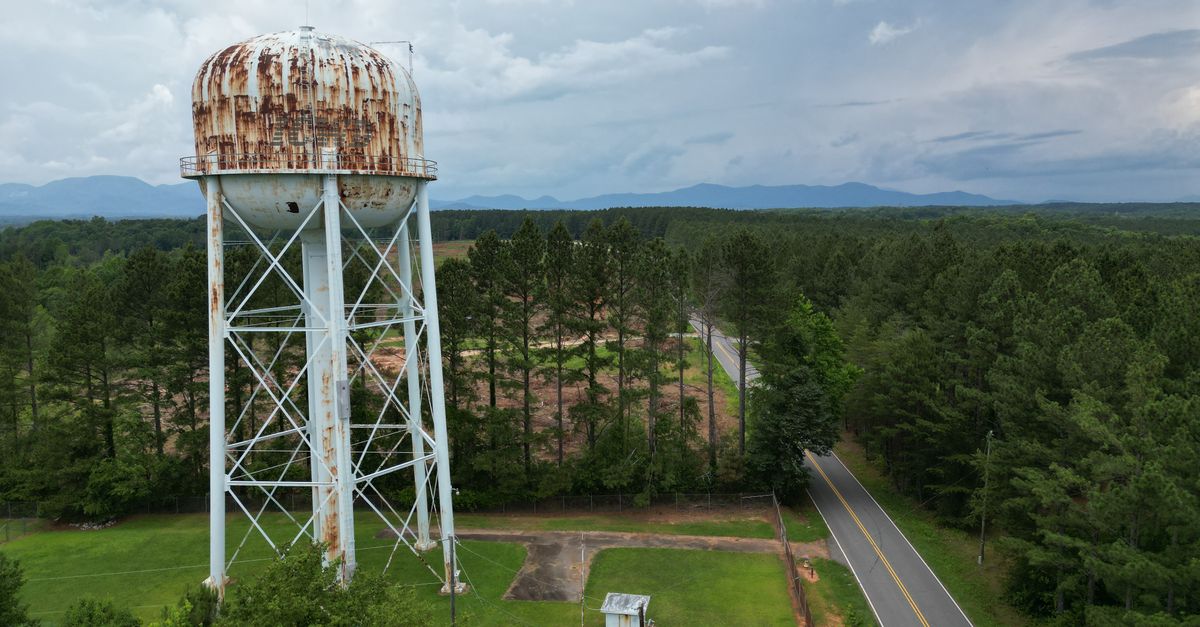 Aerial shot of an old water tower surrounded by a lush green landscape in Campobello, SC.