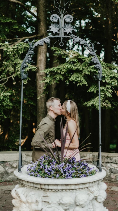 Couple Kissing behind Stone Flowerpot