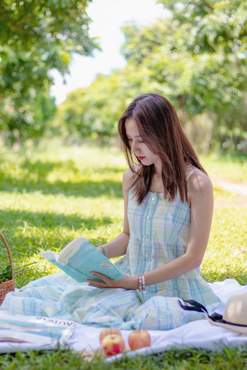 Free Woman enjoying a summer picnic in Hồ Chí Minh, reading a book outdoors. Stock Photo
