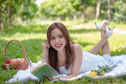 Free Woman Smiling While Holding a Book Stock Photo