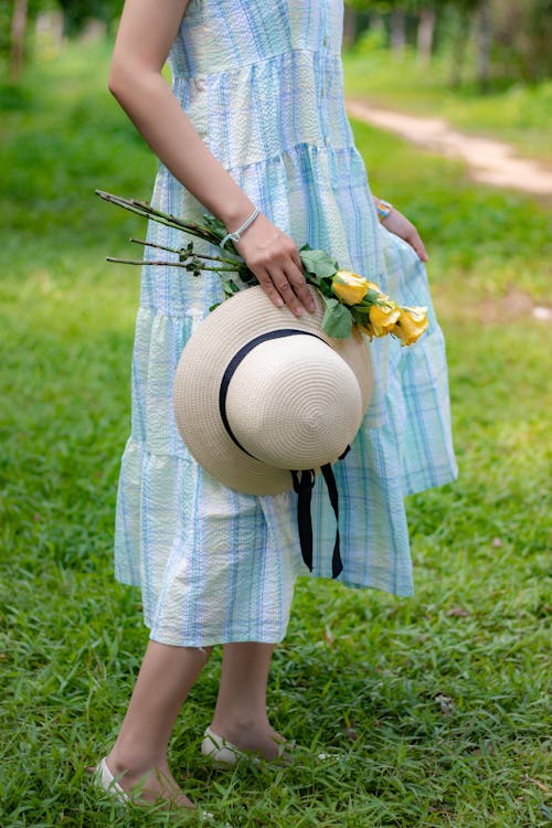 Free Woman Holding Flowers and a Hat Stock Photo