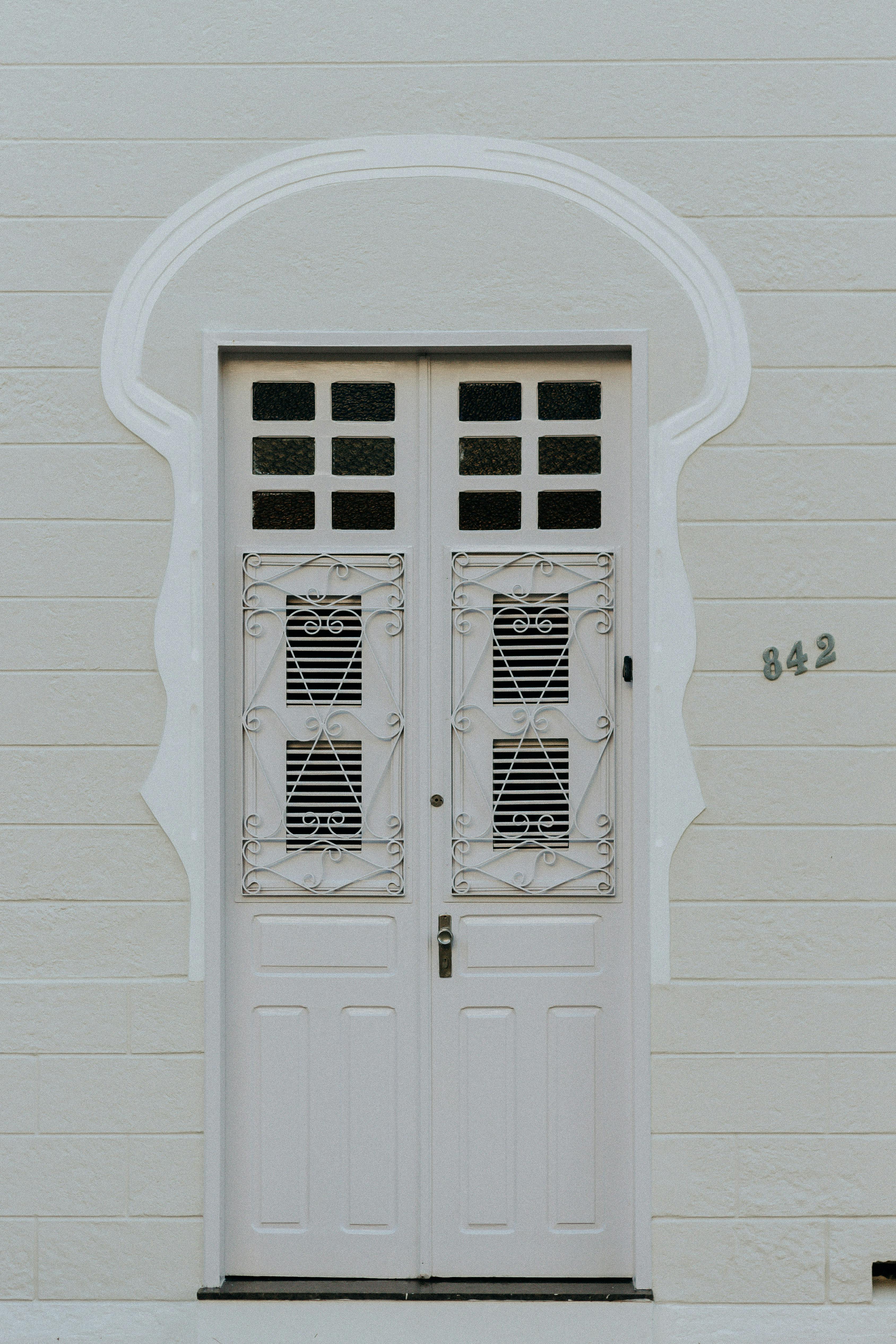Elegant white door with intricate ironwork on a house exterior wall in Aracati, Brazil.
