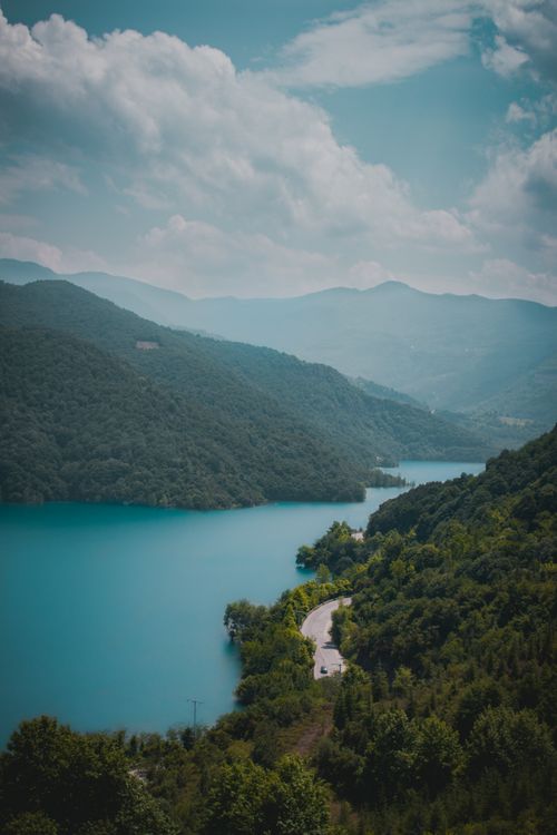 Free A breathtaking aerial view of a winding road by a lake surrounded by lush forests in Kocaeli, Turkey. Stock Photo