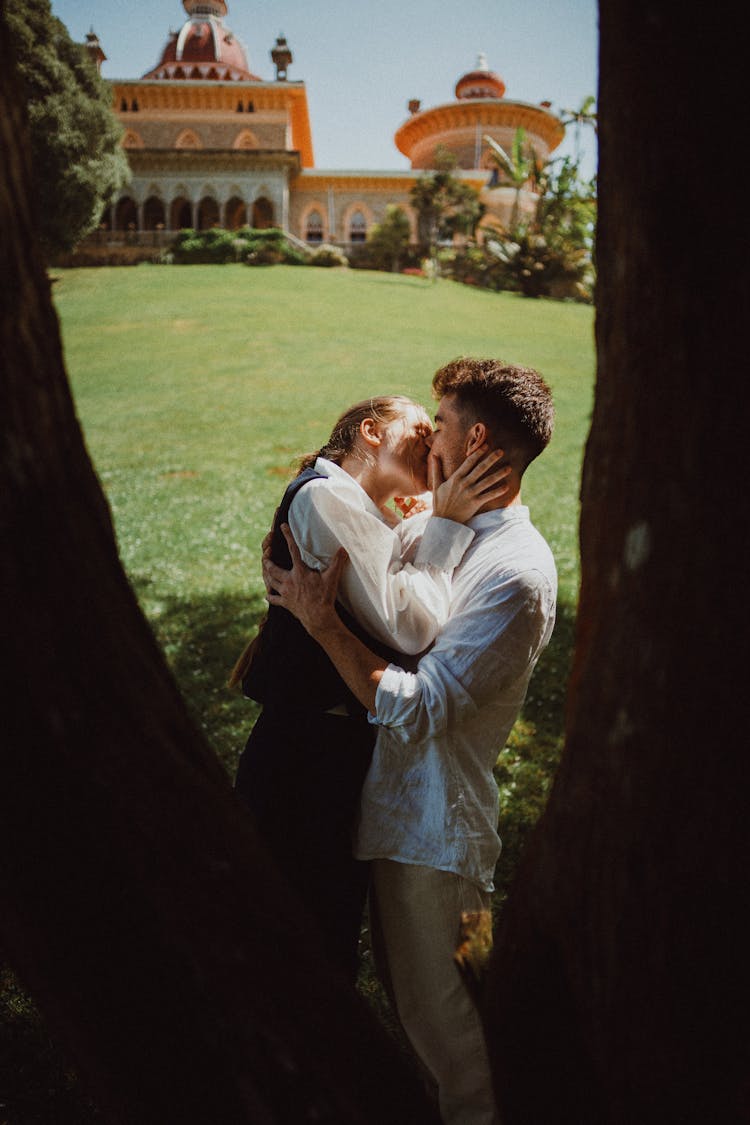 Young Couple Kissing Under Tree