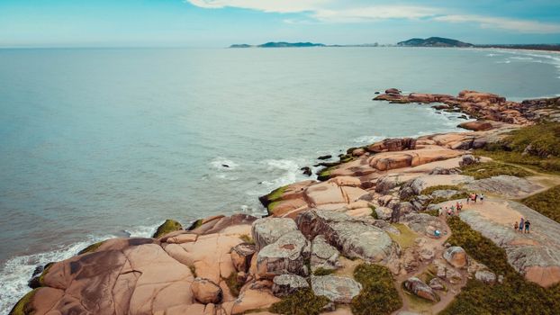A breathtaking aerial view of rocky coastline in Santa Catarina, Brazil, under a serene sky.