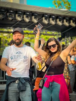 A joyful couple enjoying outdoor festivities, dancing and smiling at a street party.
