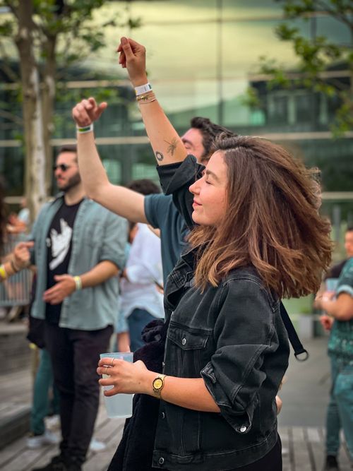 Free People enjoying a lively outdoor party, dancing and smiling under the day sky. Stock Photo
