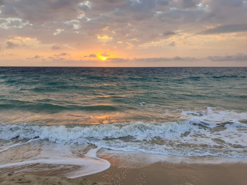 Crashing Waves on Seashore During Sunset