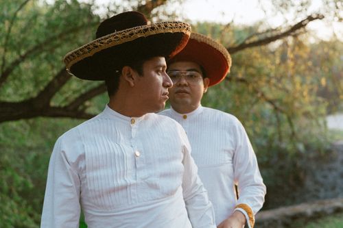 Free Two men in traditional Mexican attire with sombreros standing outdoors in a natural setting. Stock Photo