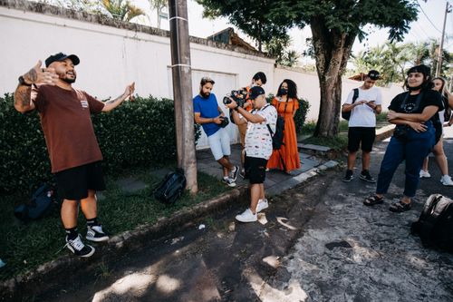 Free Energetic group of diverse adults in an outdoor photography workshop interacting and learning camera techniques. Stock Photo