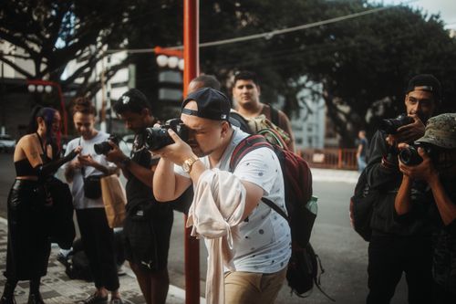 Free Group of photographers taking street photos in an urban outdoor setting. Stock Photo