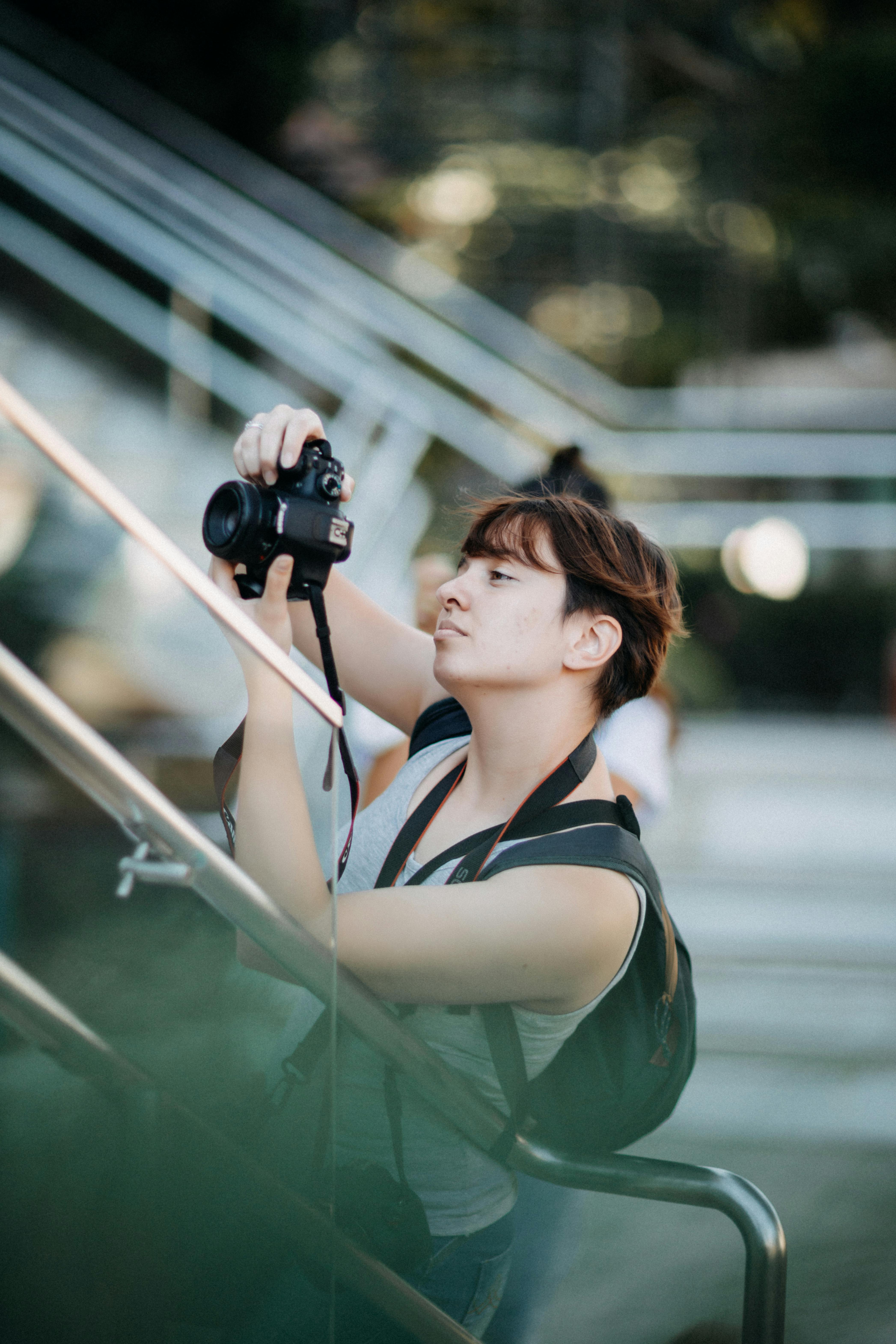 a woman in gray tank top taking phot