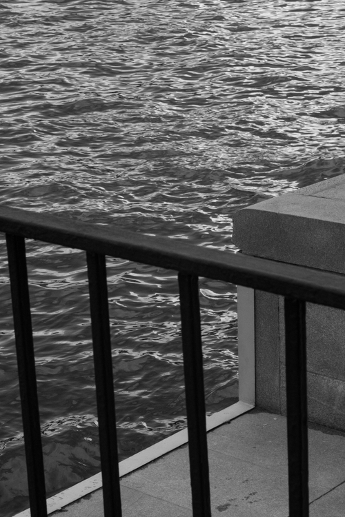Free Monochrome view of a railing by the water in an urban setting. Stock Photo