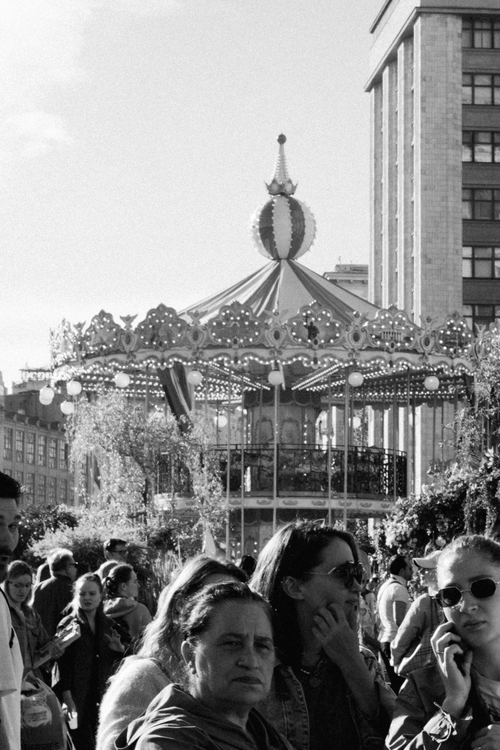 Free Monochrome image of a bustling crowd near a carousel in a city. Stock Photo