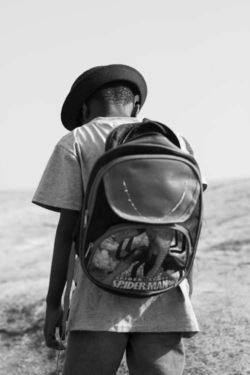 Black and White Photo of Man Wearing Backpack