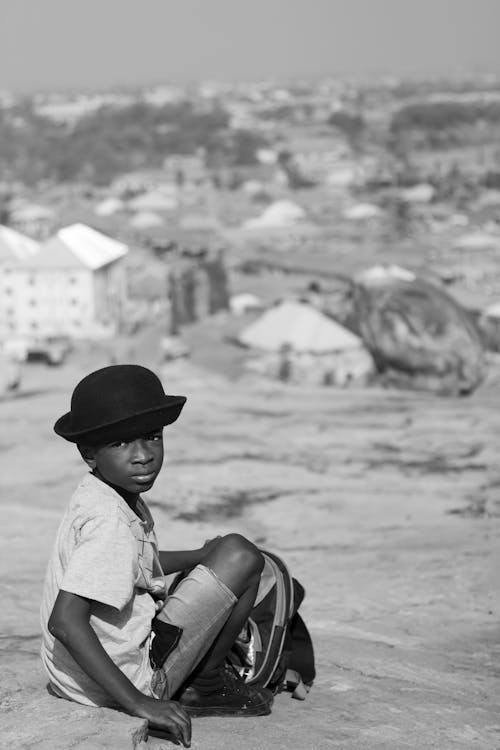 Grayscale Photo of a Kid Wearing a hat