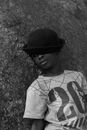 Grayscale Photo of Boy in White and Black Crew Neck Shirt and Black Hat