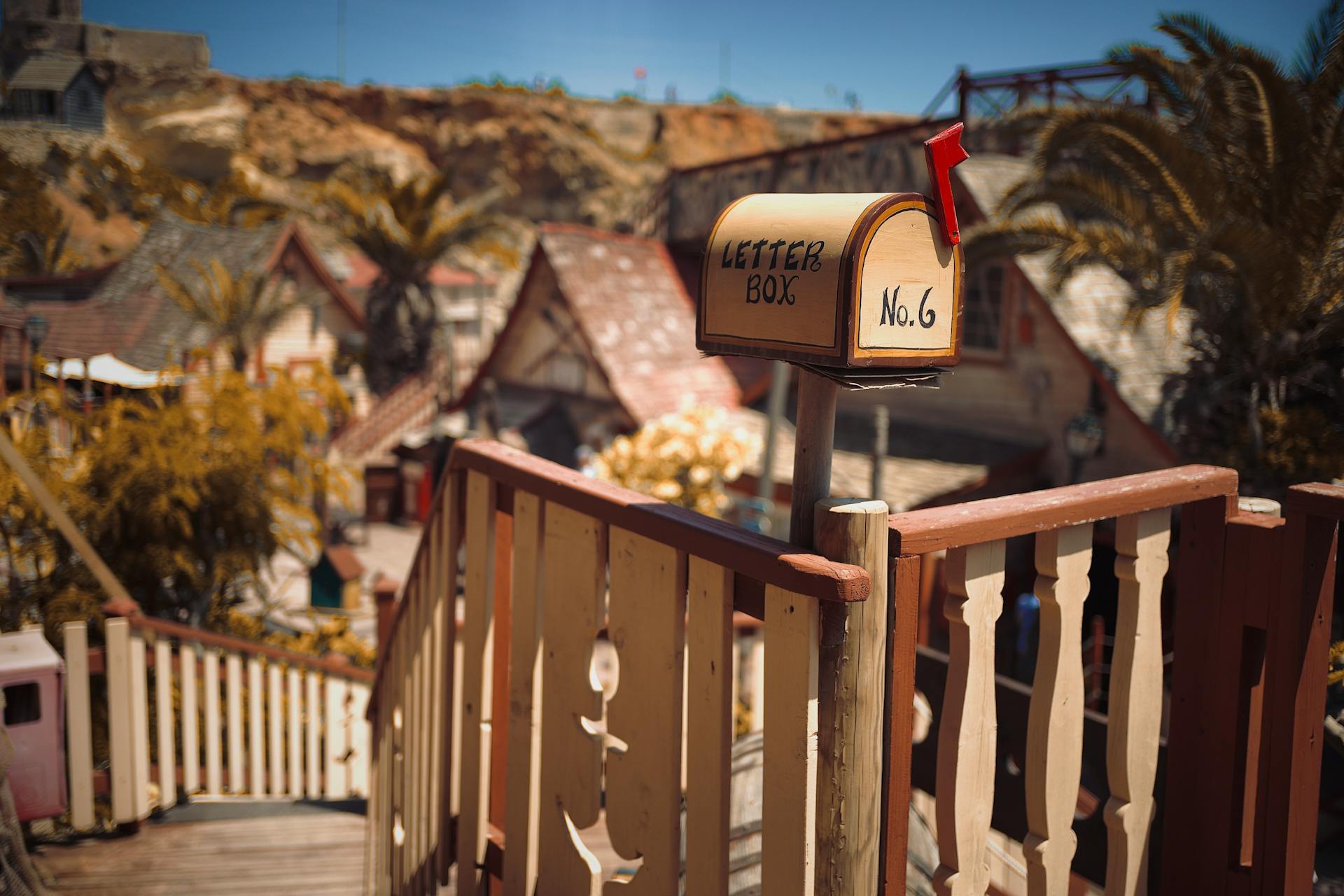 Quaint mailbox overlooking picturesque village scene, ideal for storytelling.