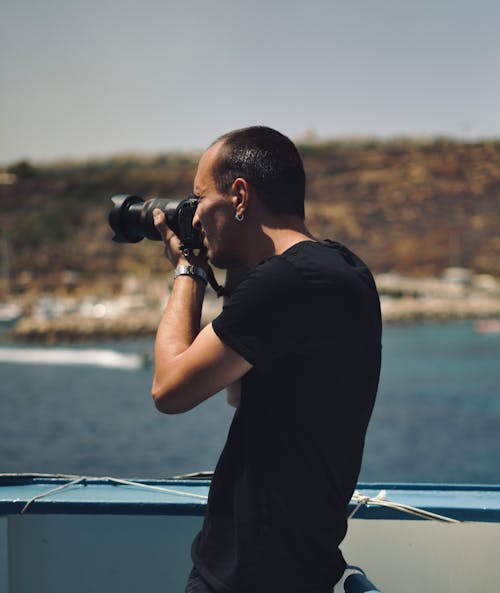 Free Man in Black Shirt Taking Photo with a Camera Stock Photo