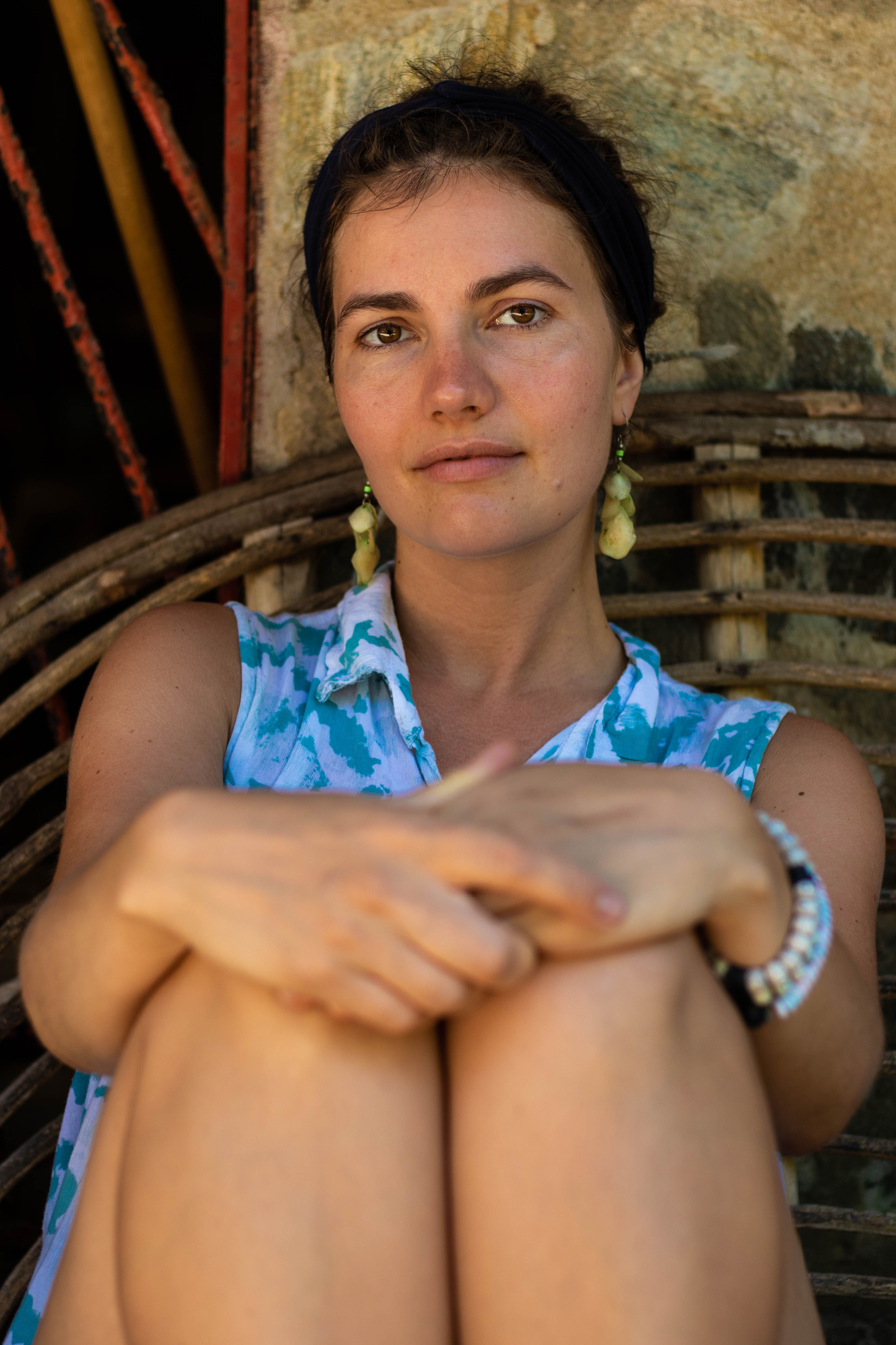 A Woman Wearing Blue Shirt Sitting on a Wicker Chair · Free Stock Photo