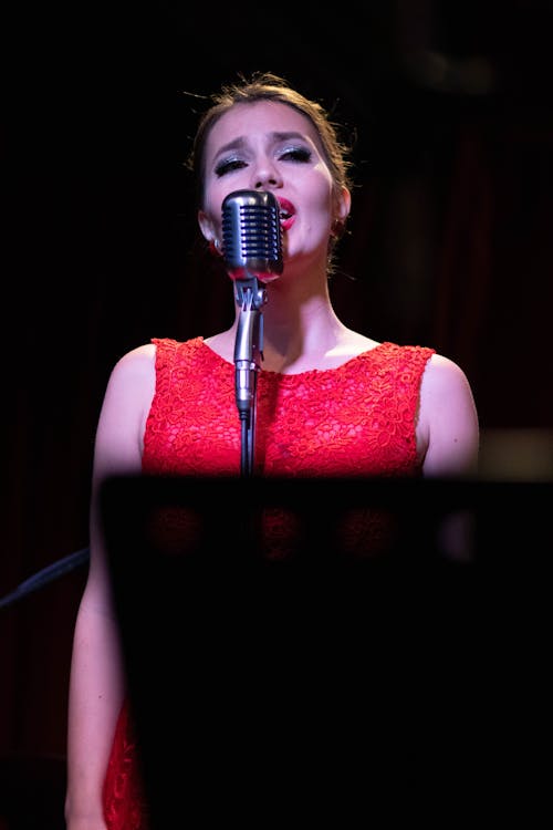 Woman in Red Dress Singing on the Stage