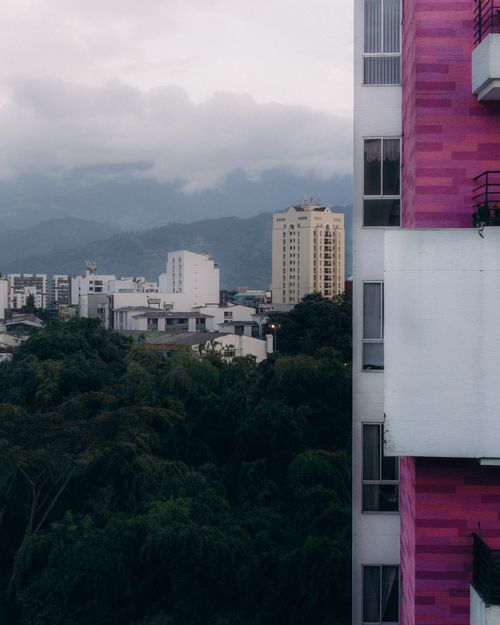 Free Captured a vibrant cityscape with a striking pink building facade against a cloudy sky. Stock Photo