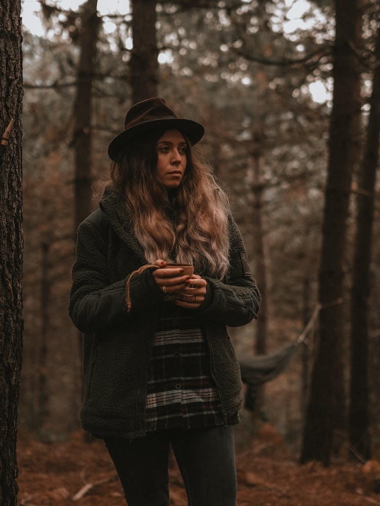 A Woman In Black Jacket Holding A Cup