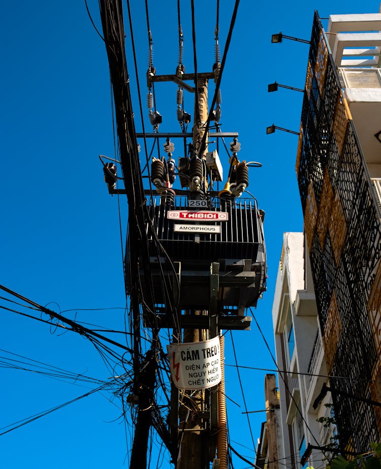 Power Transformer On Pole Against Blue Sky