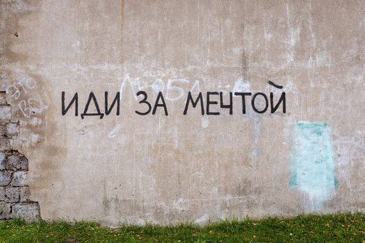 Graffiti with motivational text on an urban wall, embracing creativity and street art style.