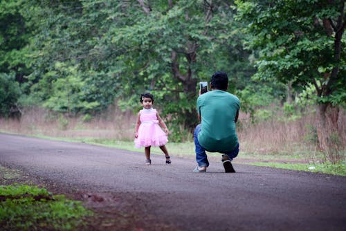 Man Taking Photo of Daughter in Pink Dress