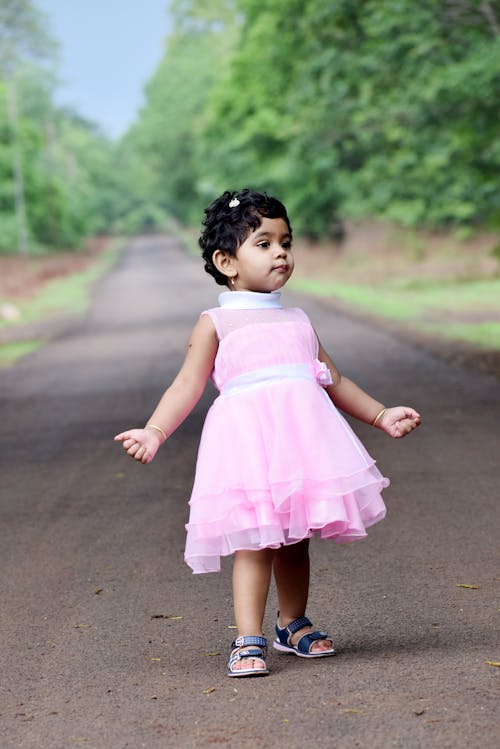 Cute Girl in Pink Dress Standing on the Road