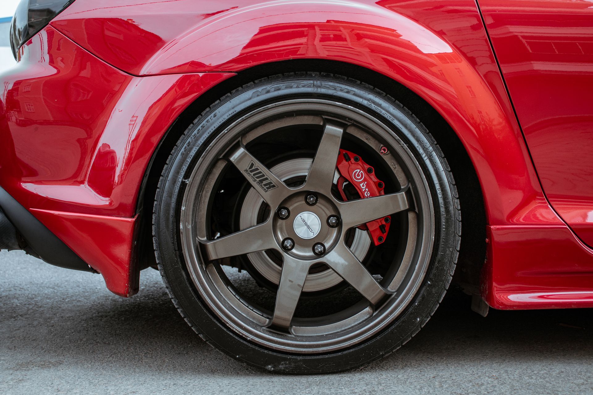 Rad und Reifen eines roten Fahrzeugs als Detailansicht