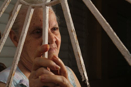 A Woman Behind White Rusty Metal Railing