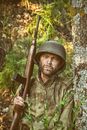 Man in Green and Brown Camouflage Uniform Holding Brown Rifle