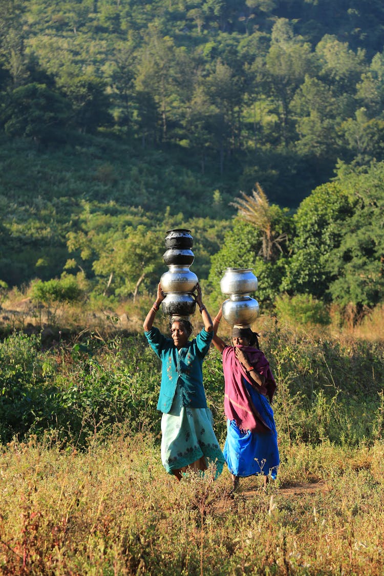 Women Carrying Vases On Heads