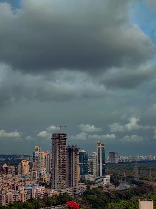 Free A city skyline featuring high-rise constructions under a dark cloudy sky, captured from above. Stock Photo