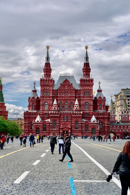 Free Tourists walking in Red Square, Moscow, with the iconic State Historical Museum in the background. Stock Photo