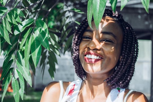 阳光明媚的户外，一位快乐的女子在郁郁葱葱的绿叶间微笑