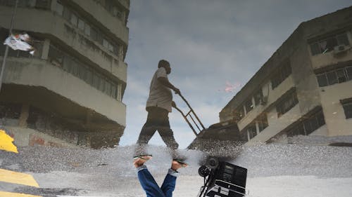 Reflection of Man with Cart in Puddle