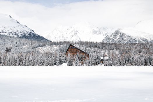 Stunning Vysoké Tatry winter landscape featuring a snow-covered hotel amidst majestic mountains.